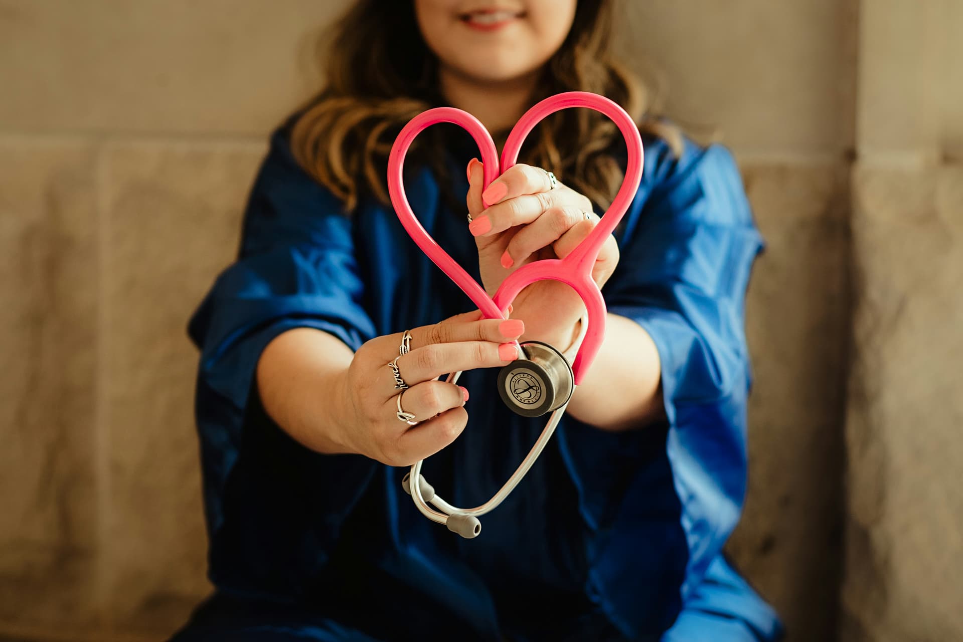 Healthcare professional holding a stethoscope heart